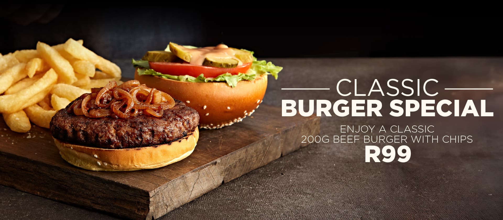 Promotional restaurant banner featuring a classic beef burger topped with caramelized onions, lettuce, tomato, pickles, and sauce, served with chips on a rustic wooden board